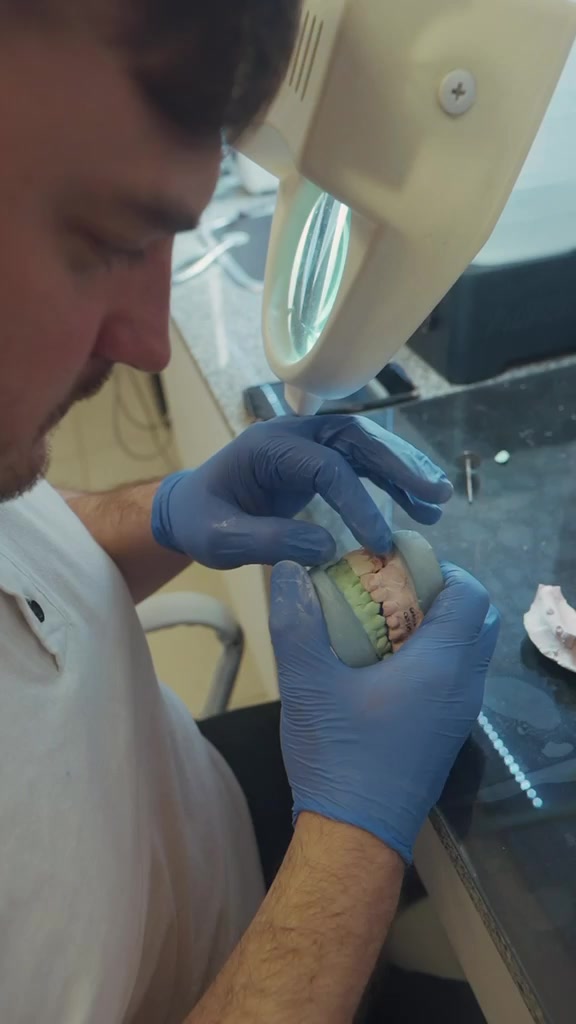 Técnico dental trabajando sobre un modelo de prótesis